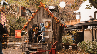 Famille costumée devant une maisonnette décorée pour l’Halloween au parc Félix-Leclerc, dans le quartier Petit-Champlain.