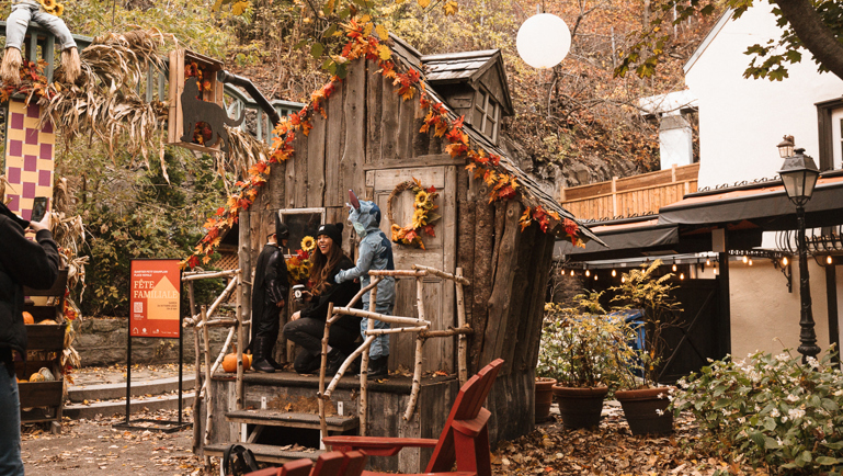 Famille costumée devant une maisonnette décorée pour l’Halloween au parc Félix-Leclerc, dans le quartier Petit-Champlain.